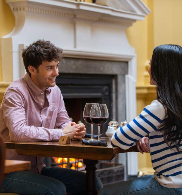 A couple enjoying a glass of wine at a dinner table