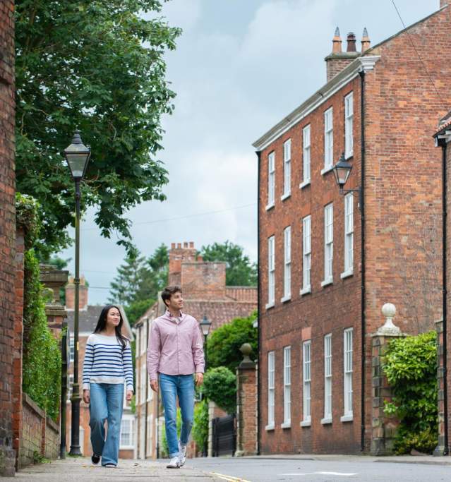 Two people walking along the street in Louth with a traditional country pub in the background