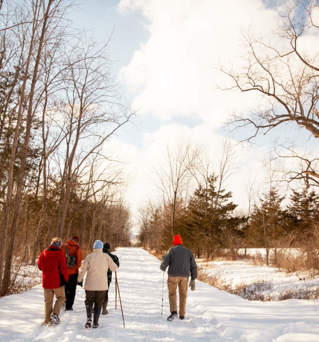 Group of people hiking down snowy trail