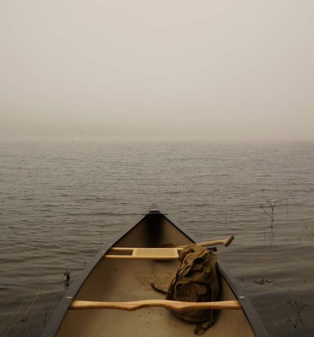 Canoe on edge of foggy lake