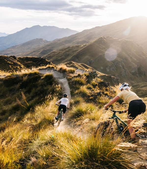 Two people riding mountain bikes through the mountains