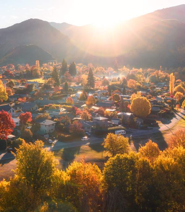 Aerial photo of Arrowtown full of gold and red trees in Autumn