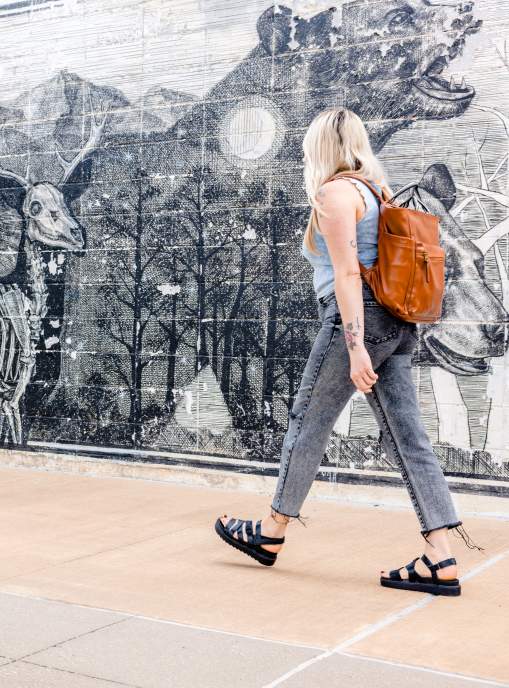 A woman walks by a black and white mural
