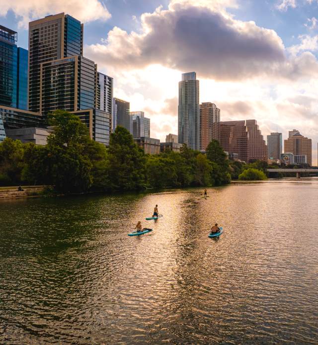 People stand up paddleboarding on Lady Bird Lake.