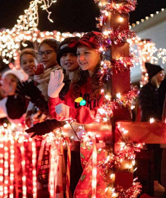 Photo of children smiling and waving on a lighted parade float during the Christmas Parade in downtown Brownwood.