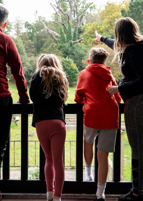 Family looking out to garden from balcony at accommodation lodge in the New Forest