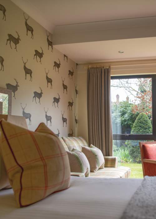 Careys Manor Bedroom Interior, bed, table and view outside through double doors