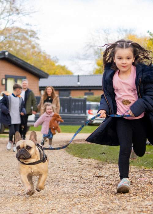 Girl running with her dog at holiday park in the New Forest