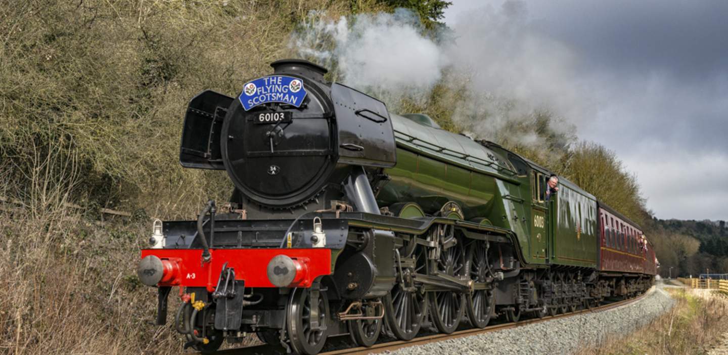A lovely old steam engine chuffing through the north york moors, a blue plaque on its nose saying "the flying scotsman"