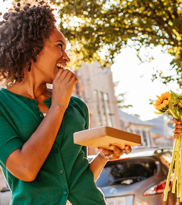 A woman and man smile at each other on the sidewalk in downtown Carlisle, PA