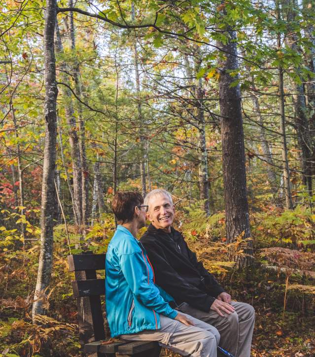 Couple Chats on Bench in Woods