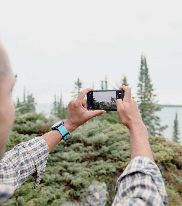 Man taking picture at Isle Royale with phone