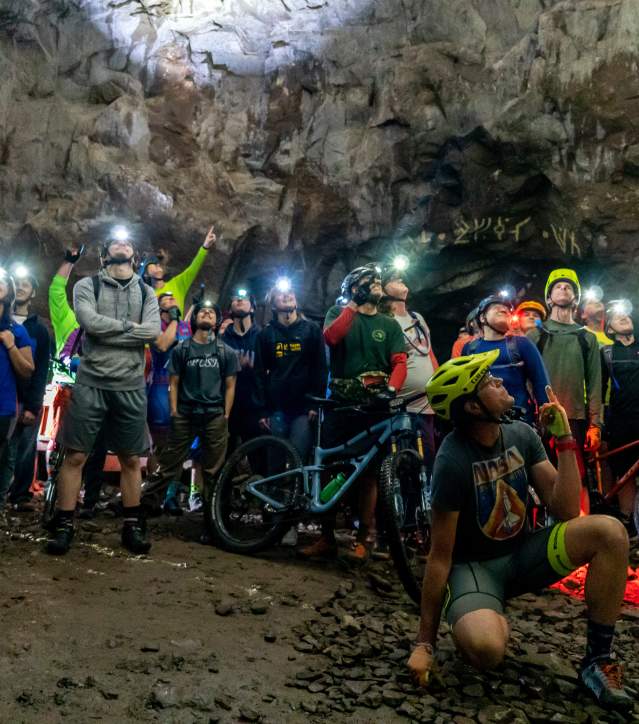 Large group of bikers pose for a photo underground at the Adventure Mine