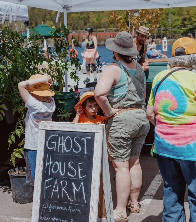 people check out goods on a waterfront farmers market