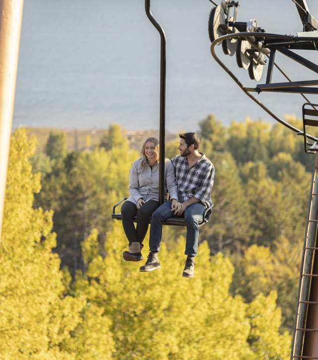 A couple enjoying a fall color chairlift ride