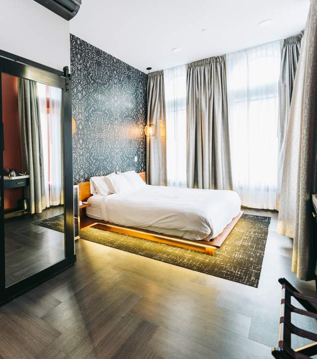 A boutique hotel room with bed and vanity