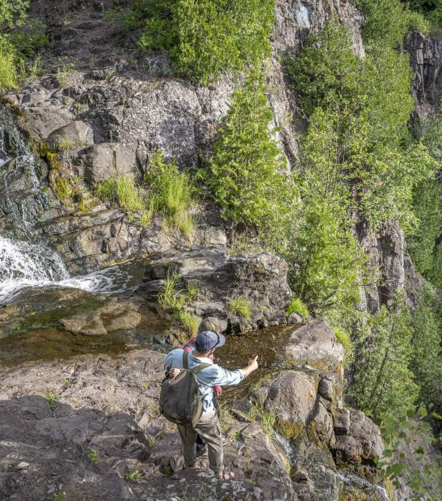 Man stands at the top of Houghton-Douglass Falls