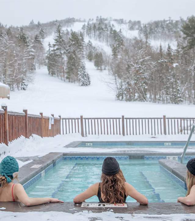 Three women relax at the nordic spa at Mount Bohemia