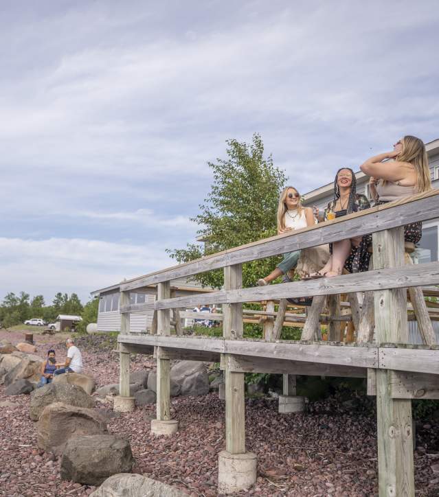 people sit on an outside deck patio with drinks