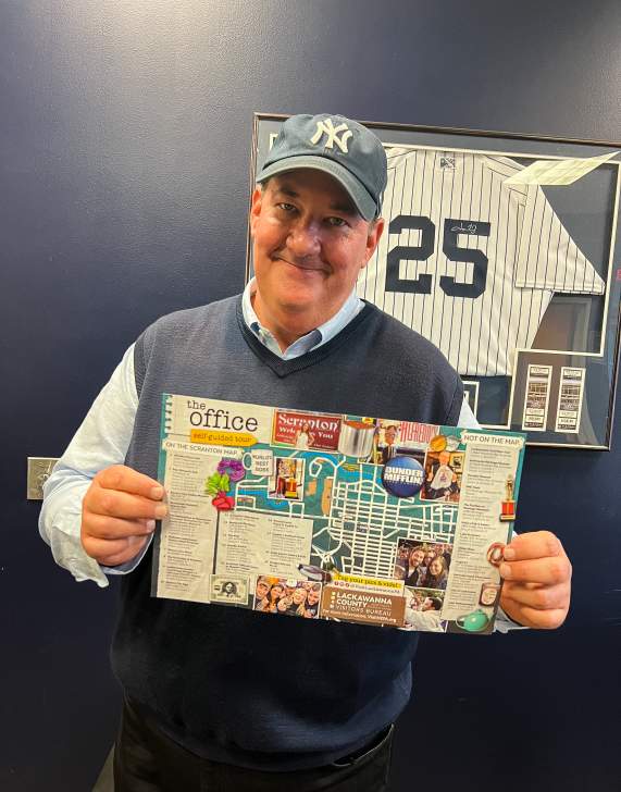 Brian Baumgartner (aka Kevin from The Office tv show) holding The Office Self-Guided Tour map
