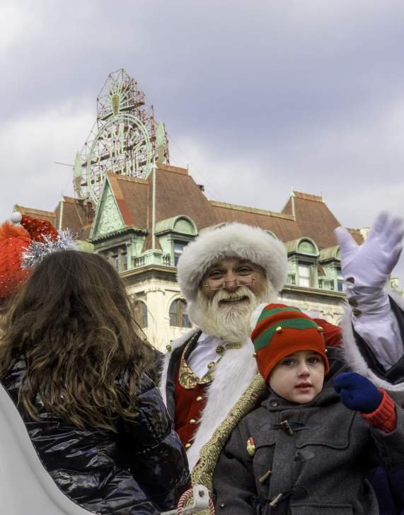 Santa and child waiving while sitting in a sleigh