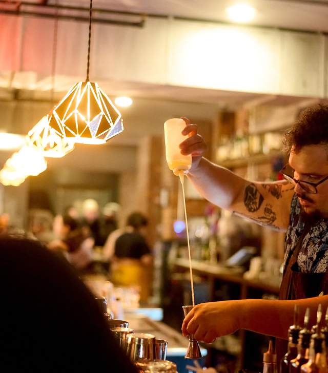 This is an image of a bartender making a craft cocktail at the Archives Bar. A vintage arcade bar in Burlington, VT