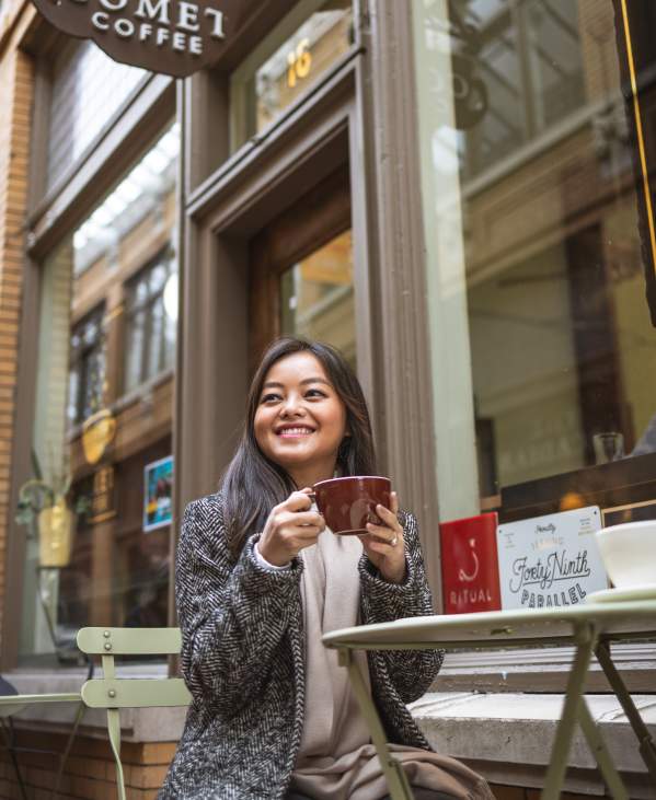Woman sitting at table outside Comet Coffee