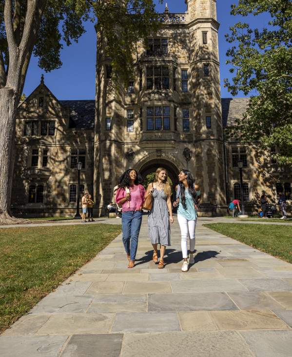 Three college-aged women walking together in U-M Law Quad in Summer