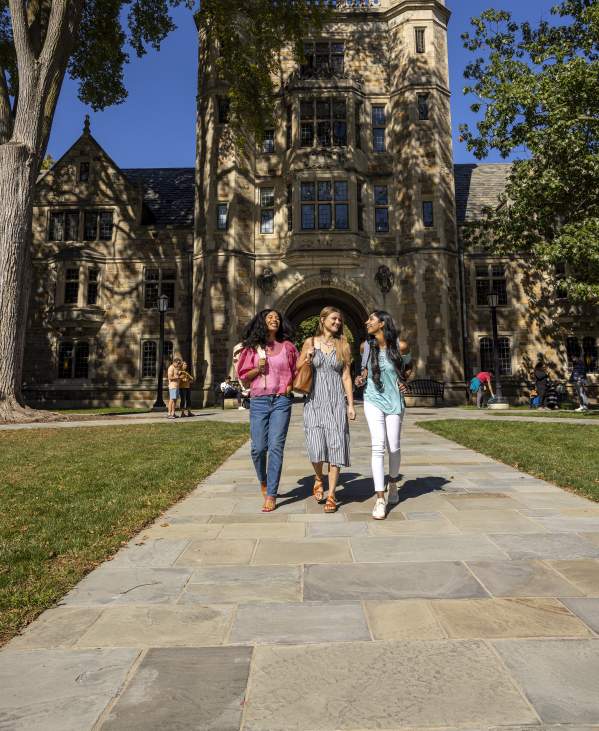 Three college-aged women walking together in U-M Law Quad in Summer