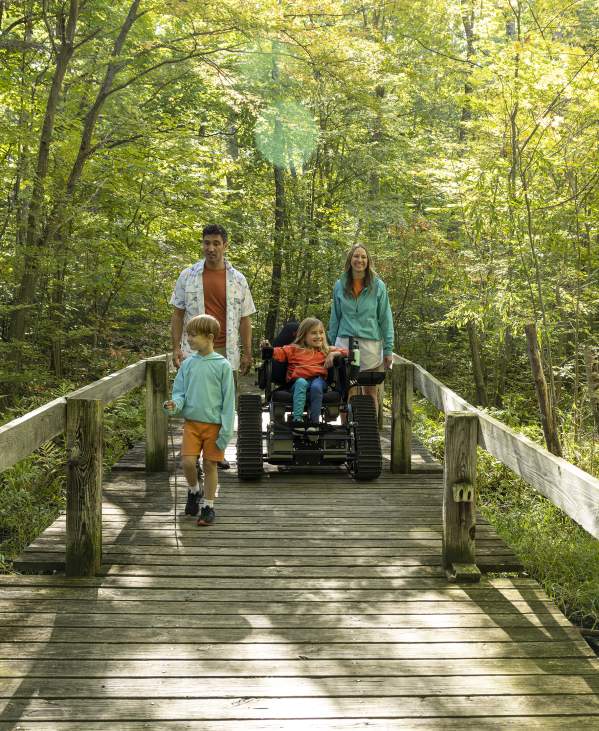 Family with daughter in wheelchair on hiking trail