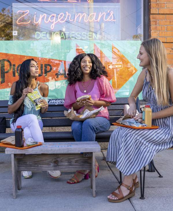 3 women eating out in front of Zingerman's Deli