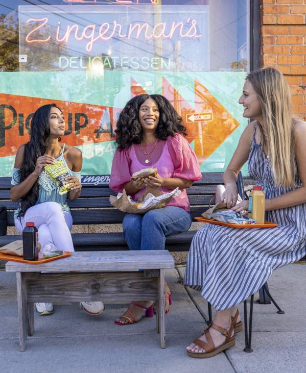 3 women eating out in front of Zingerman's Deli