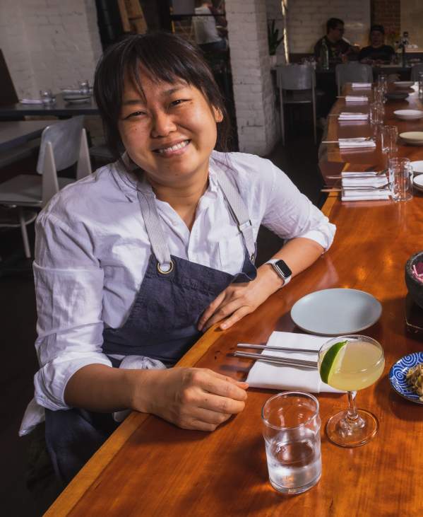 Chef Ji Hye Kim at a table of Korean food