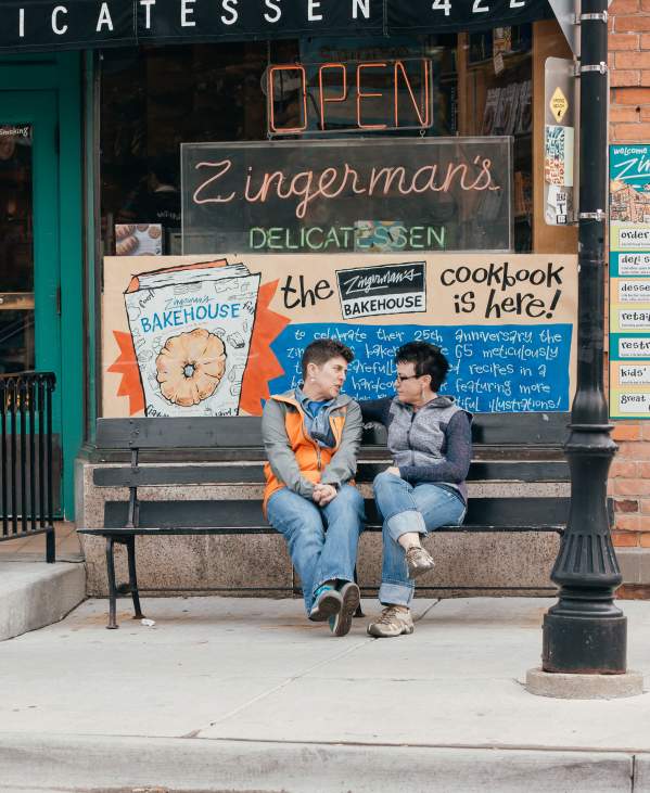 Female couple sitting on bench outside Zingerman's Deli