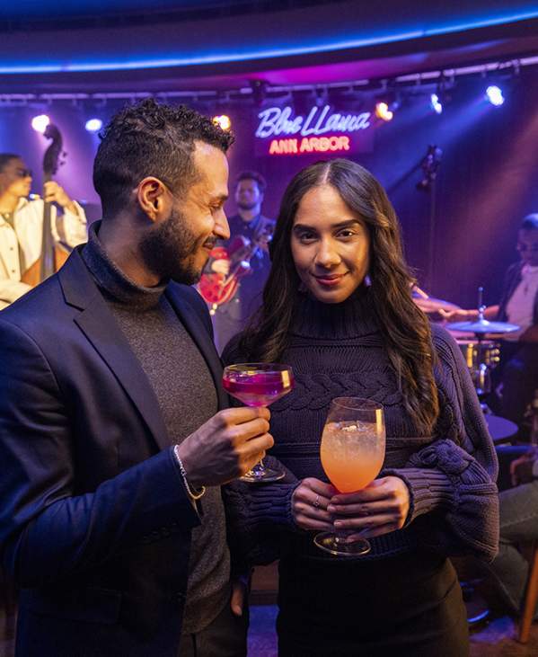Stylish couple holding drinks at Blue Llama Jazz Club