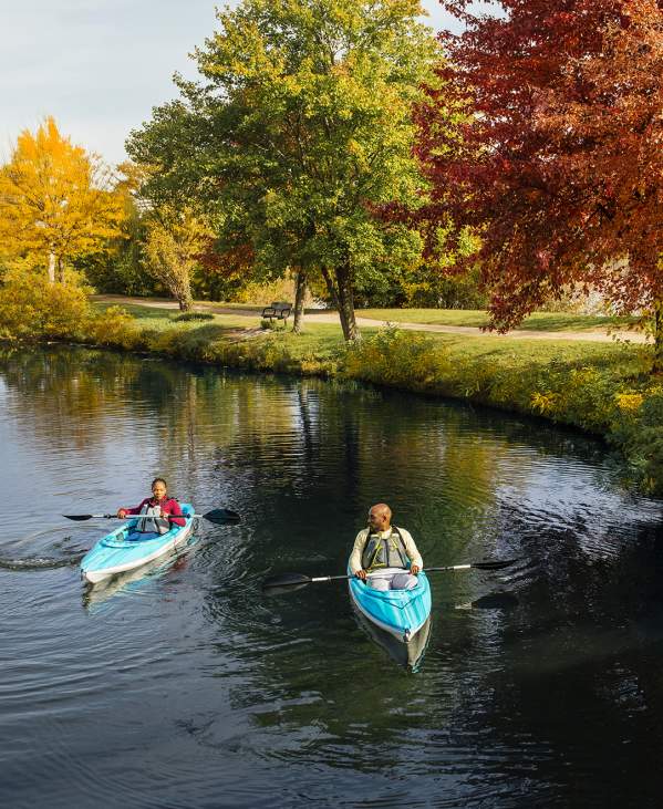 Couple in two kayaks floating on a lake in the fall