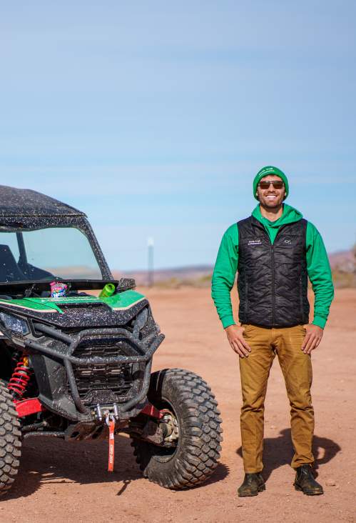 A Moab Trail Ambassador stands next to an OHV