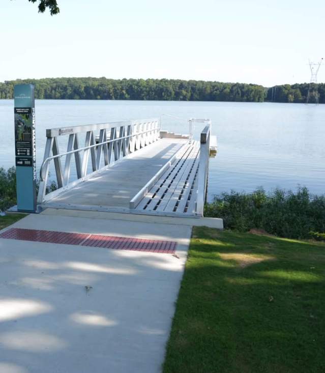 Point Mallard Paddle Area sign with a map of accessible water access points along the Tennessee River in Decatur, Alabama, with the river visible in the background.