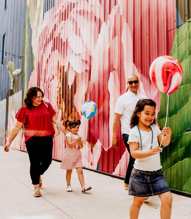 Family walking by Peony mural on The Landing
