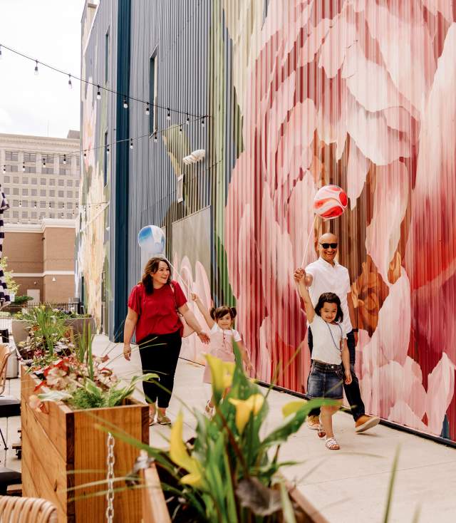 A family strolls along The Landing enjoys public art in Fort Wayne, Indiana.