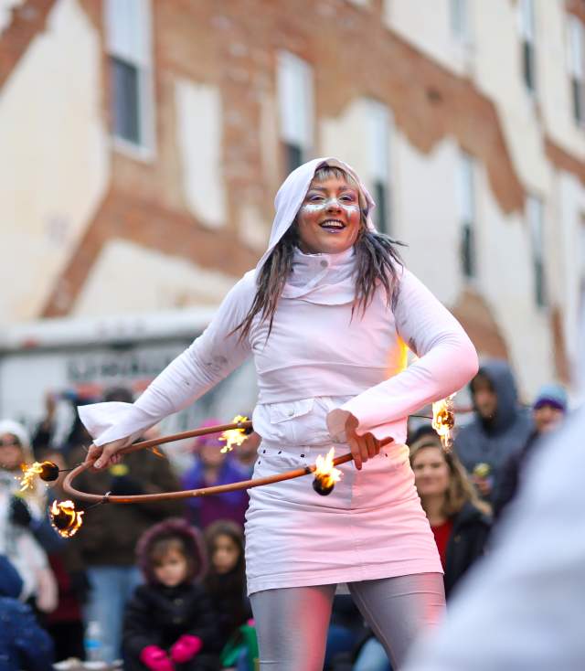 woman fire dancer performing at outdoor winter festival