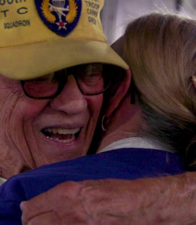 Veteran hugging woman at military reunion.