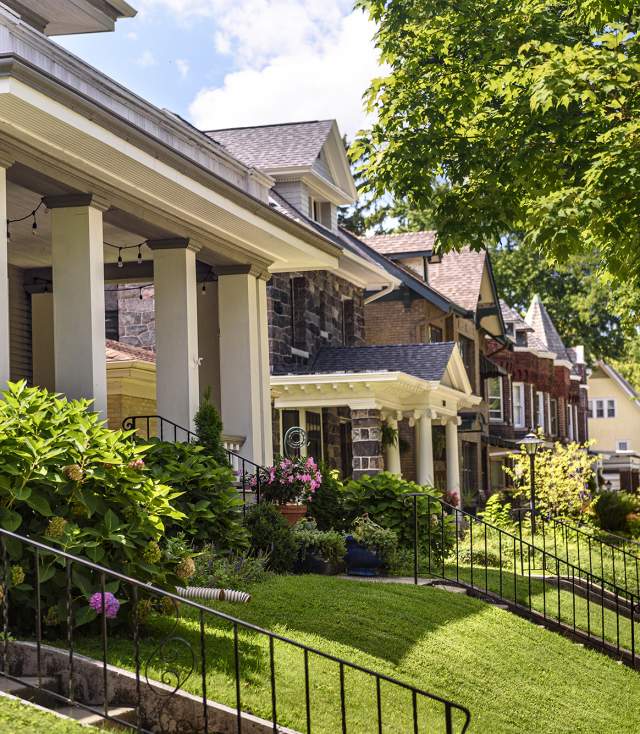 a row of historic homes with a sidewalk running along the front