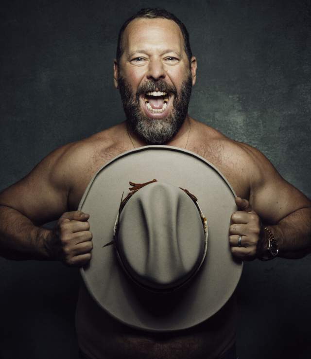 Bert Kreischer holding a hat in front of his chest