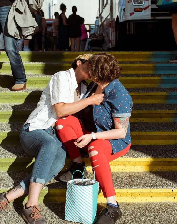 Two people kissing on stairs.