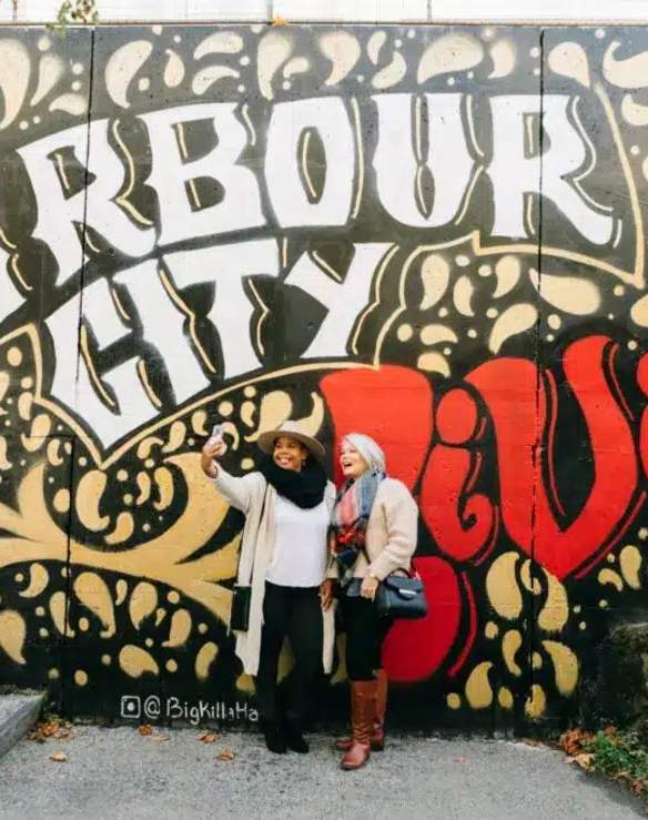 People taking a selfie at a mural.