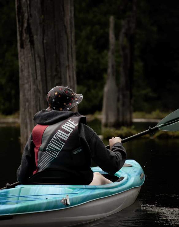 A person kayaking in a drowned forest.
