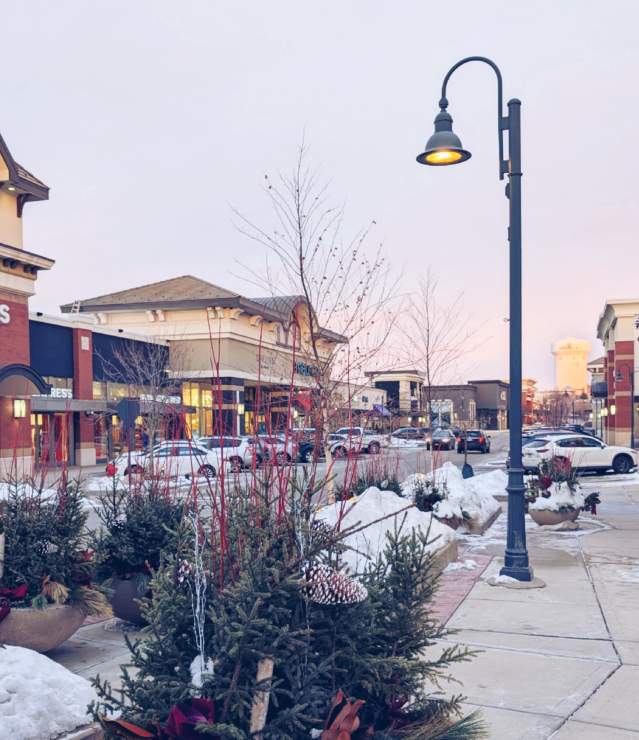 Woodbury Lakes shopping Center in winter showing greenery, light post and stores in a "main street" setting.
