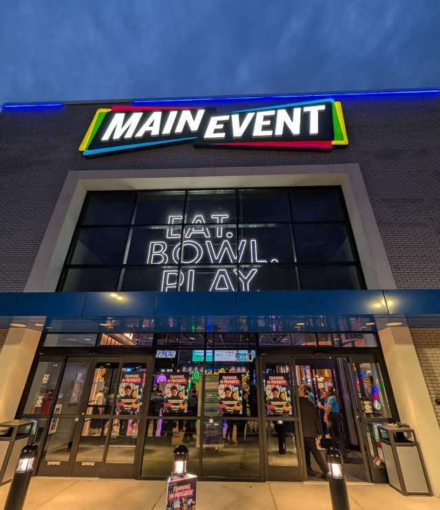 Main Event preview opening in Woodbury showing exterior signs lit up with "Eat. Bowl. Play"
