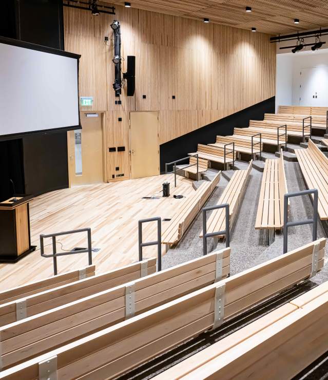 Central Park indoor amphitheater space with screen and podium shown.
